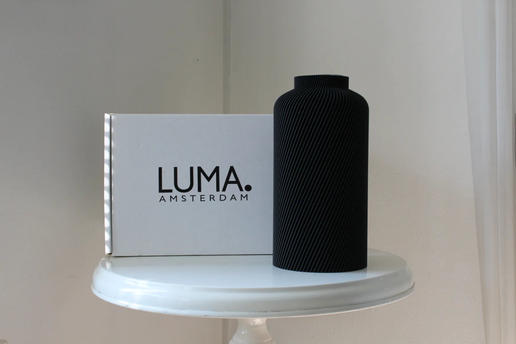 A black SILO vase beside a LUMA. amsterdam box