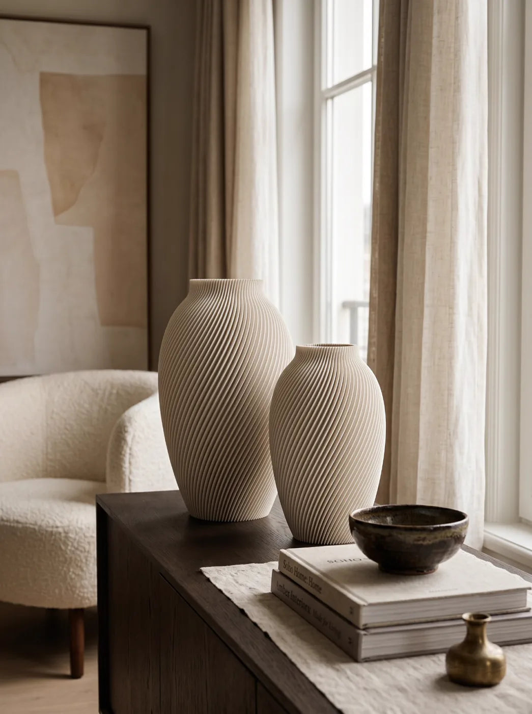 Two sand SPIRE vases on a sideboard by a window