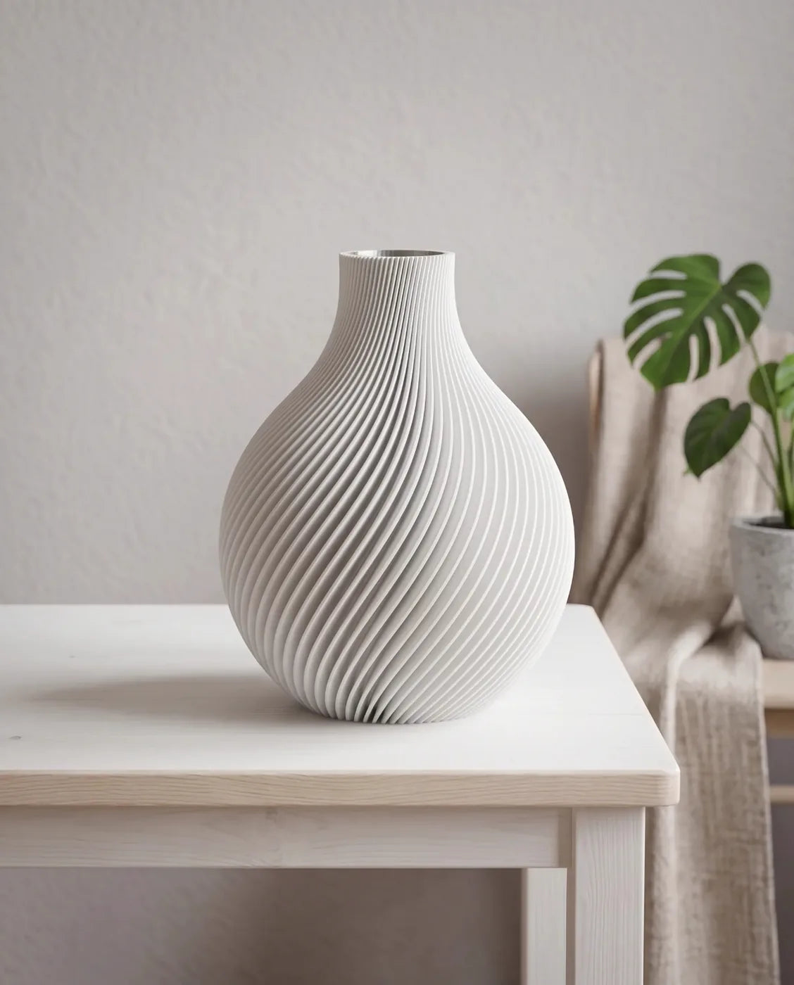White ORB vase with spiral ribs beside a monstera plant